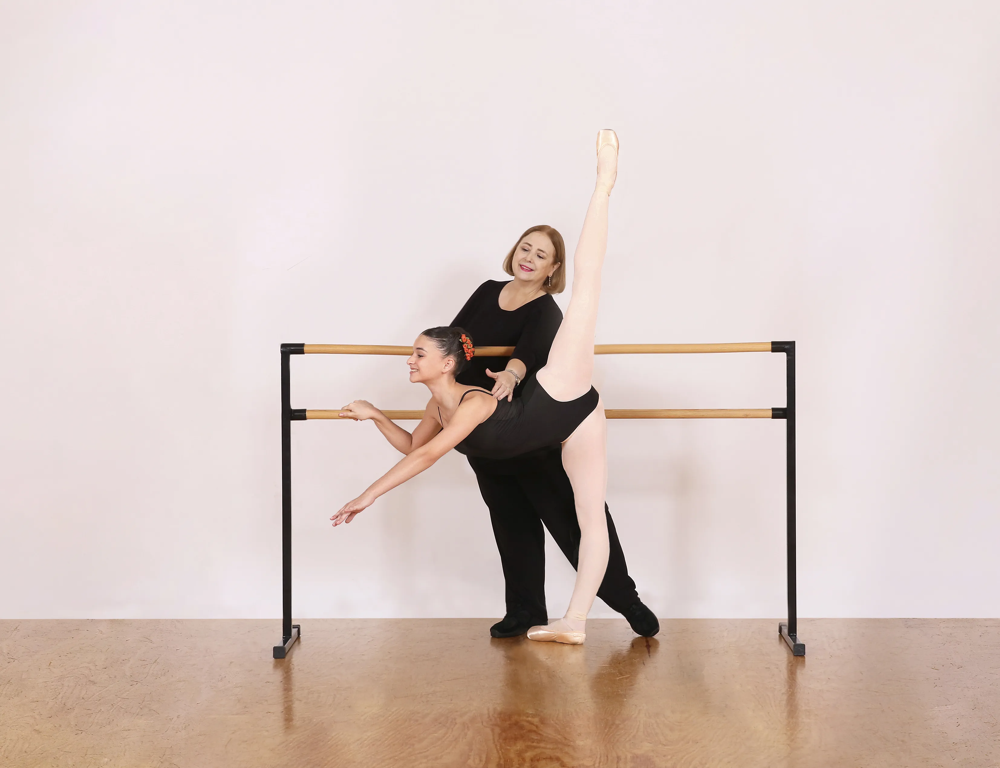 Maestra de ballet enseñando técnica en la barra
